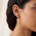 Aretes Corazón con ojo dorados puestos