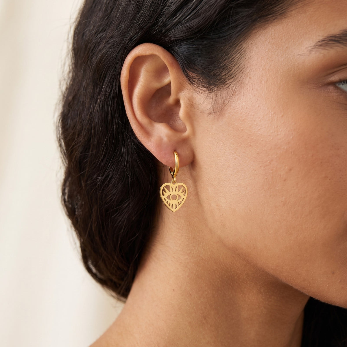 Aretes Corazón con ojo dorados puestos