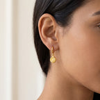 Aretes Medalla de sol dorados puestos