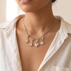 Collar Fígaro plateado con charms de sol, estrella de mar, corazón y concha puesto