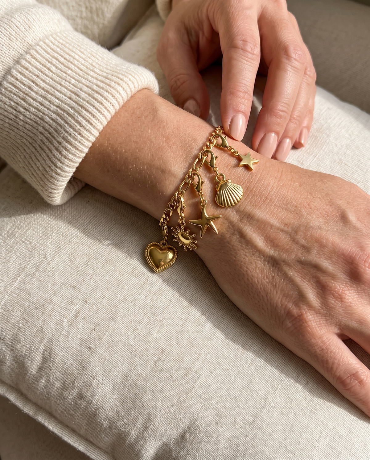 Pulsera Fígaro dorada con charms de corazón, sol, estrella de mar, concha y estrella puesta