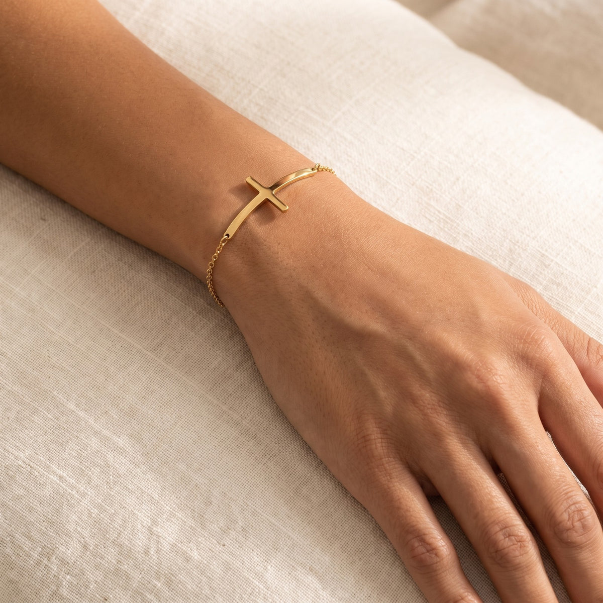 Pulsera Cruz curva dorada puesta