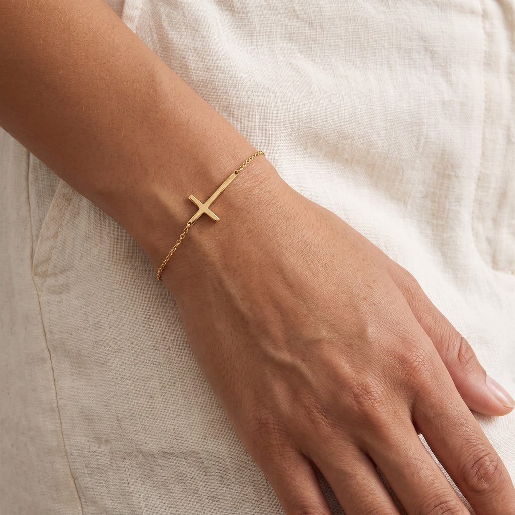 Pulsera Cruz de lado dorada puesta