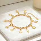 Pulsera Fígaro con charms dorados calados