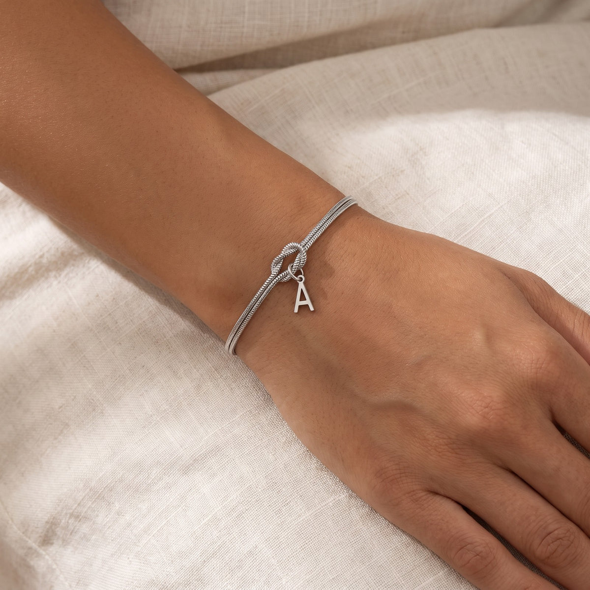 Pulsera Nudo con inicial plateada puesta